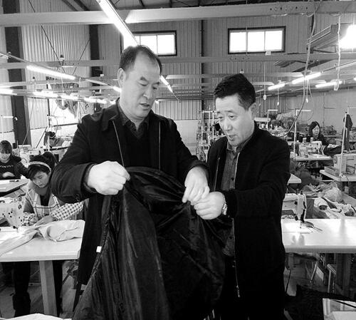 省纤检局局长胡省(左)和副局长刘群岳在校服生产车间调研3.jpg